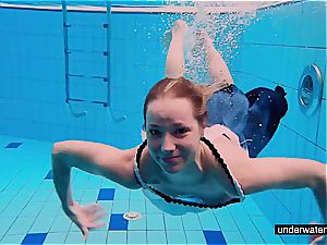 ginger-haired honey swimming nude in the pool
